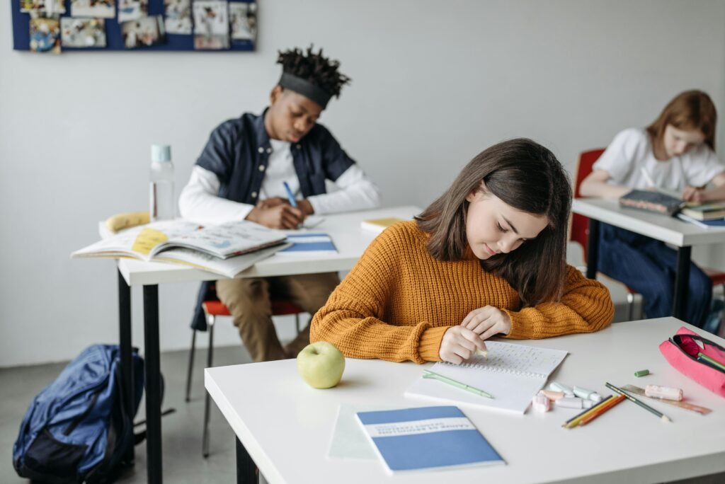 Students focused on schoolwork in a classroom setting, highlighting diversity and education.