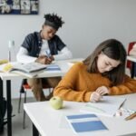 Students focused on schoolwork in a classroom setting, highlighting diversity and education.