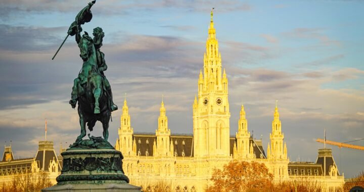 Captivating view of an equestrian statue with the iconic Vienna Rathaus at sunrise.